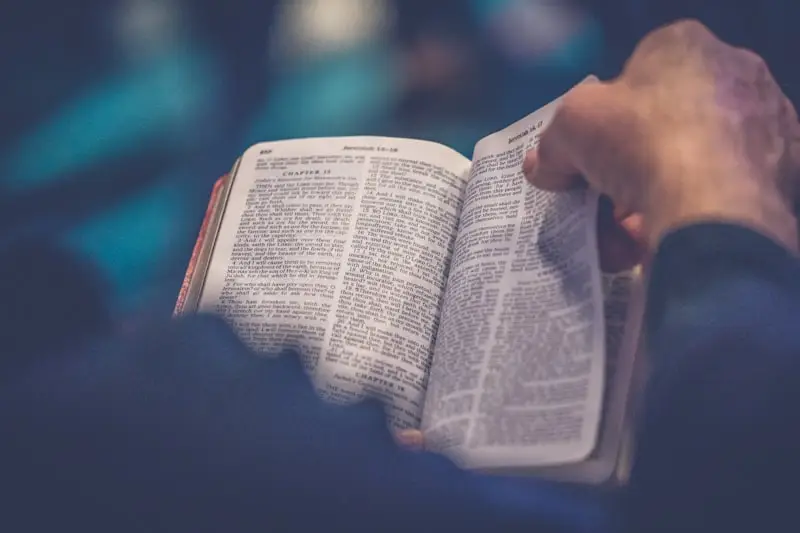 Manos sosteniendo una Biblia abierta durante la lectura